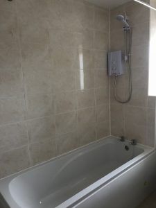 A new bath and shower installed with fully tiled walls. Part of a bathroom installation in Bicester.