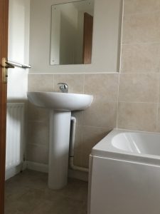 A new basin and pedestal with tiling behind. Part of a bathroom installation in Bicester.